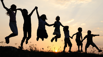 Silhouette of playing children at sunset.
