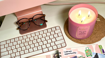 A work from home set up with a lit candle