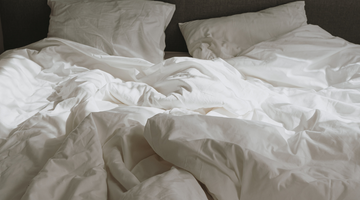 Cozy white bedding on a bed.