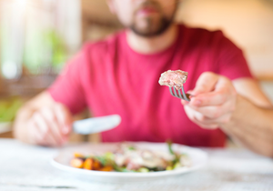 Person holding a fork with food on it.