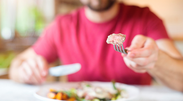 Person holding a fork with food on it.